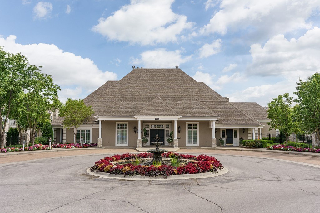 the front of a house with a fountain in the center