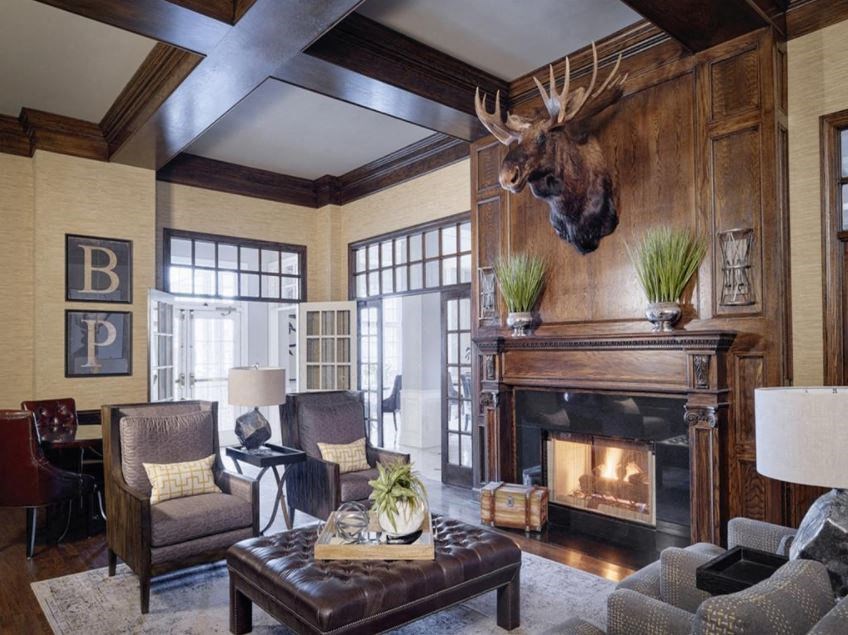 a living room with a fireplace and a deer head on the wall