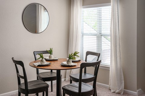 a dining room with a table and chairs and a mirror