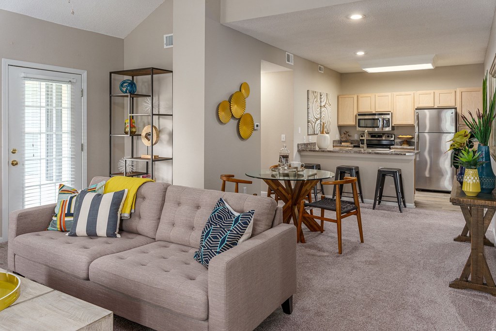 a living room with a couch and a kitchen in the background