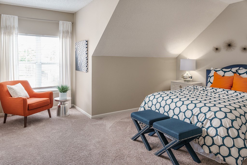 a bedroom with a bed and a chair and a table