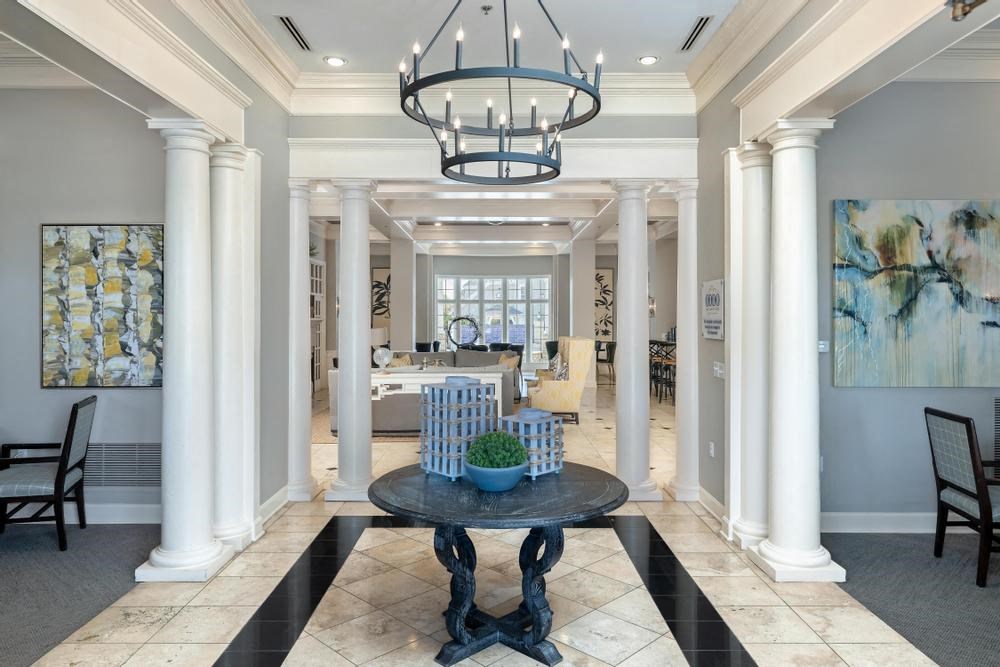 a large room with columns and a table and a chandelier