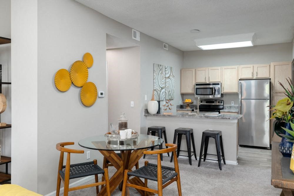 a living room and kitchen with a table and stools