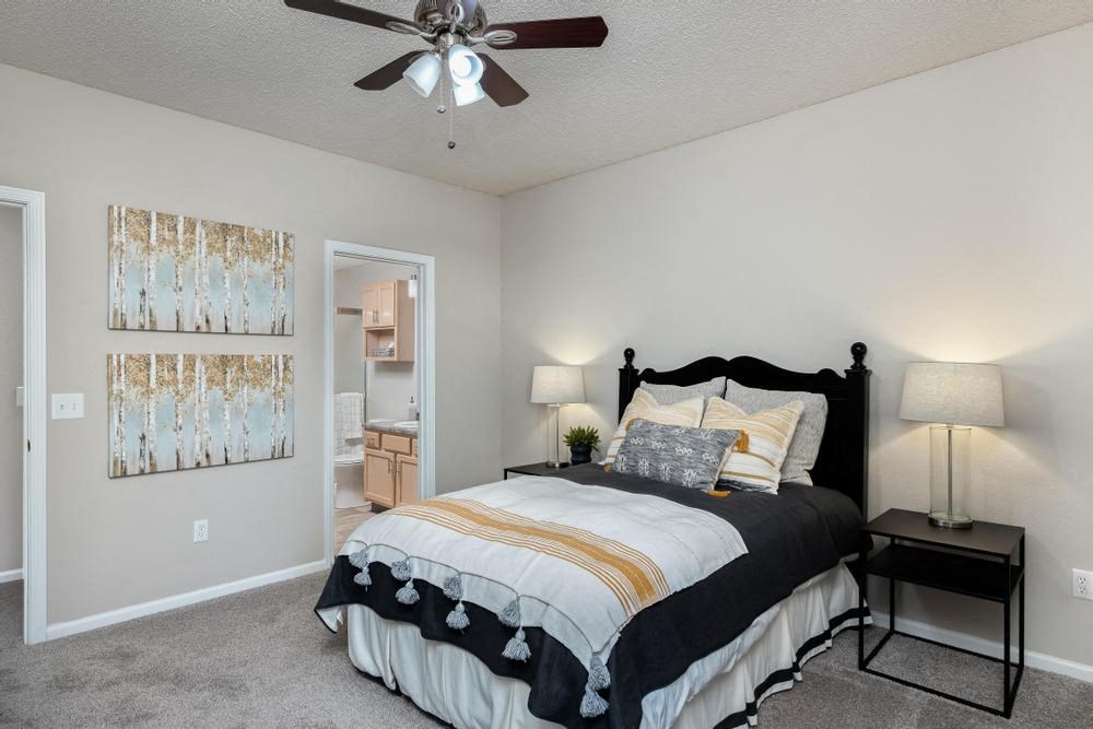 a bedroom with a bed and a ceiling fan