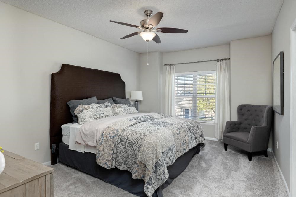 a bedroom with a bed and a ceiling fan