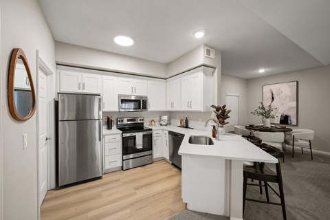 A modern kitchen with white cabinets and stainless steel appliances.