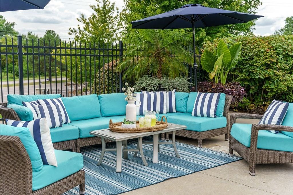 a patio with blue and white furniture and an umbrella