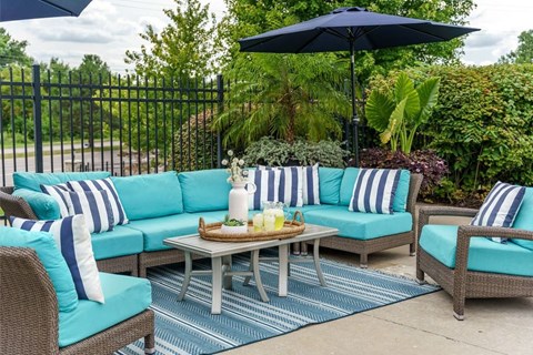 a patio with blue and white furniture and an umbrella