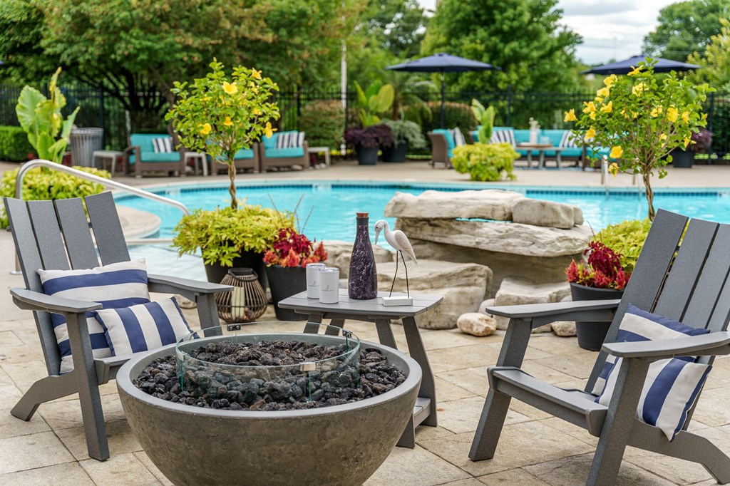 a swimming pool with chairs and tables around it