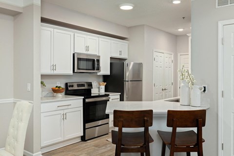 a kitchen with white cabinets and a table with chairs
