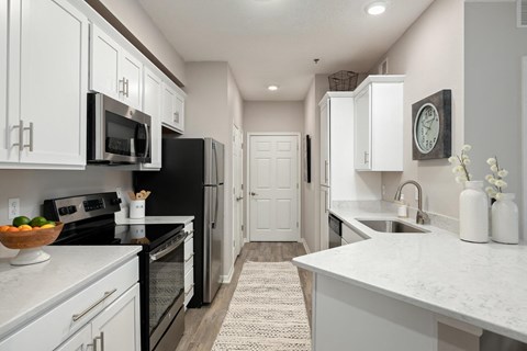 an open kitchen with white cabinets and black appliances