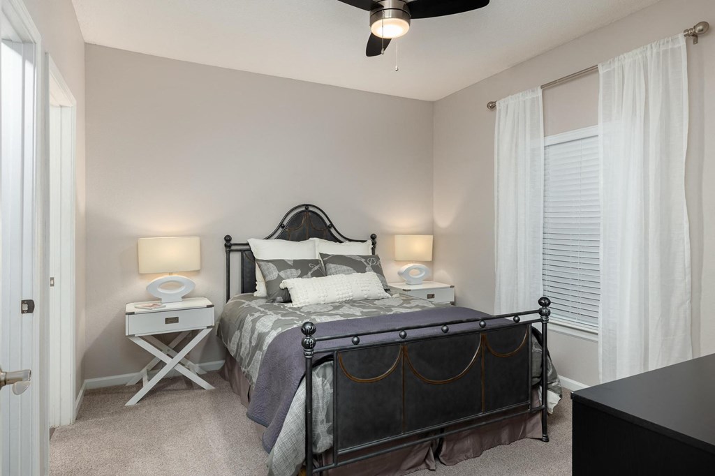 a bedroom with a bed and a ceiling fan