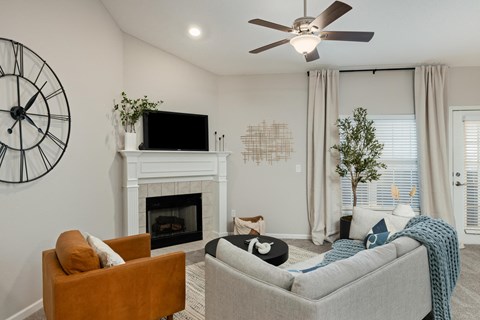 the living room has a fireplace and a large clock on the wall