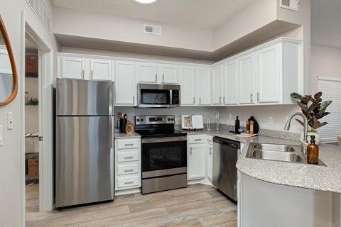 a kitchen with stainless steel appliances and white cabinets