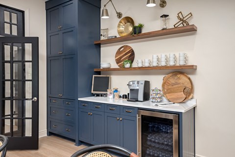 a kitchen with blue cabinets and a counter top with a coffee maker and a microwave