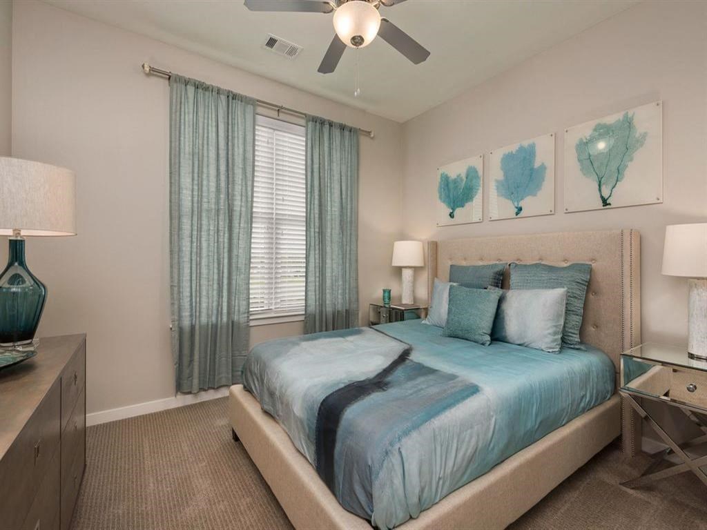 a bedroom with a bed and a ceiling fan