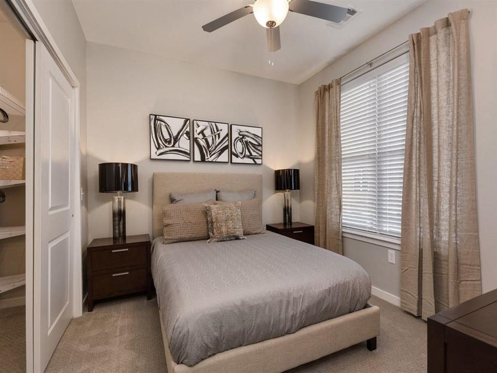 a bedroom with a bed and a ceiling fan