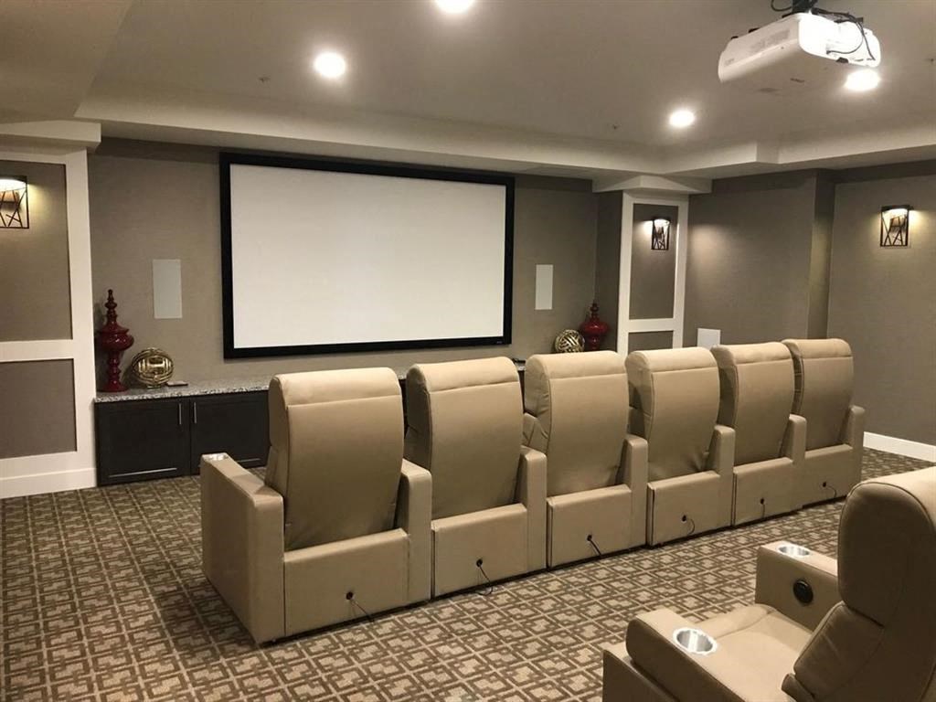 a large screening room with a projector screen and chairs