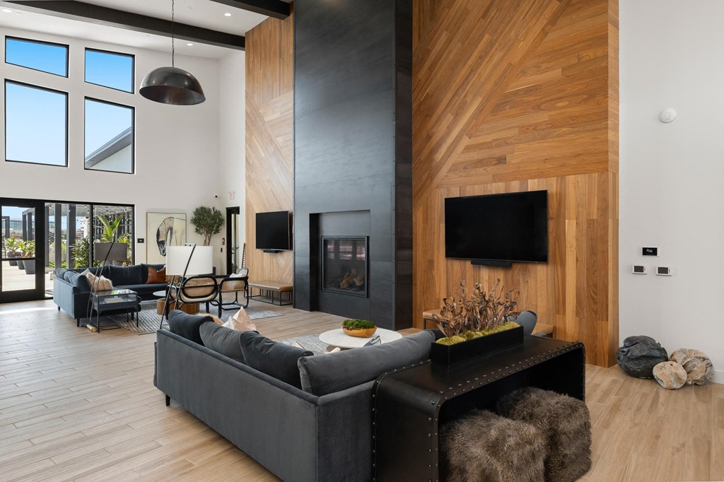 a living room with a black couch and a fireplace