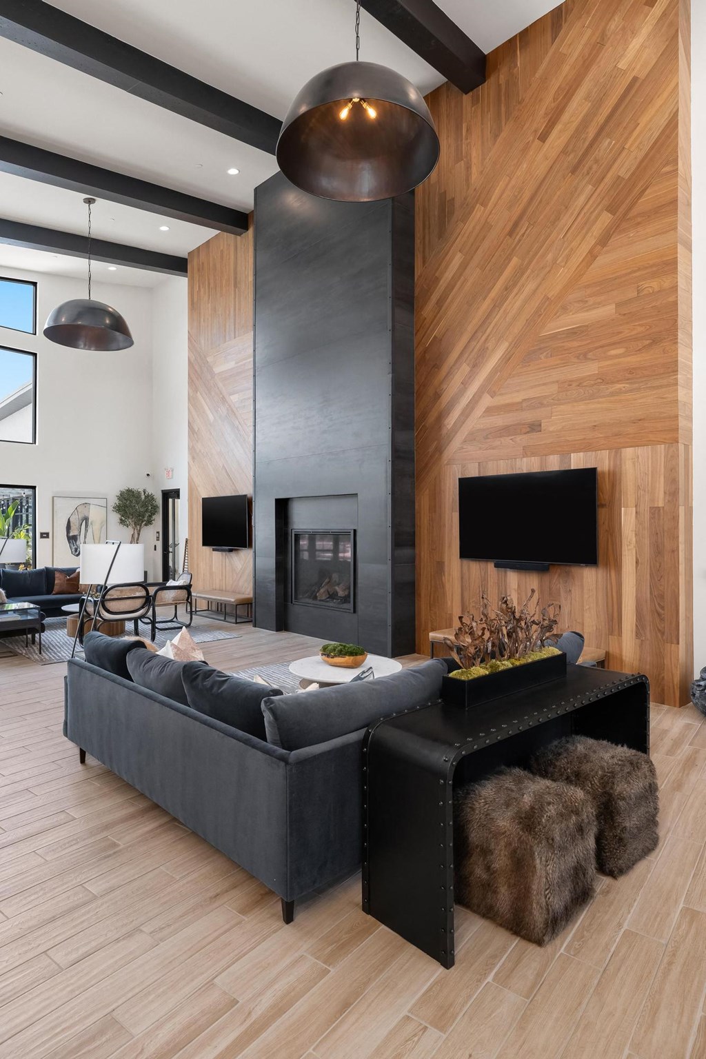 a living room with a black couch and a fireplace