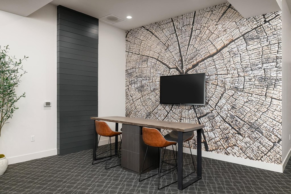 a room with a desk and a wall mural of a tree