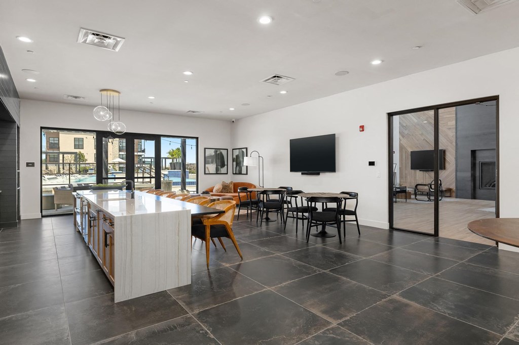 a large room with a kitchen and a table with chairs