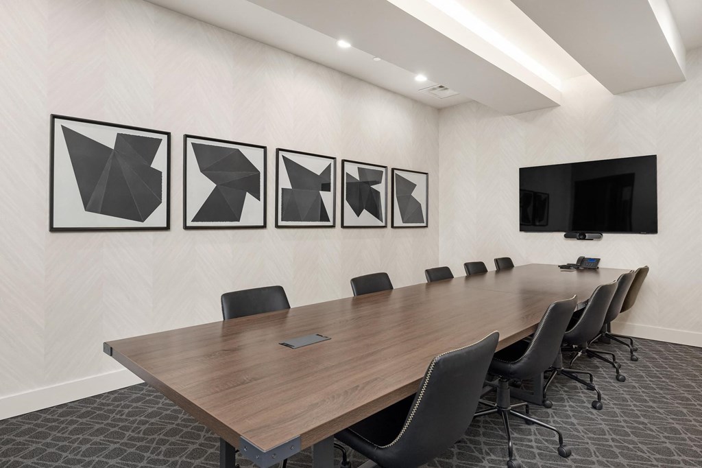 a conference room with a long table and chairs and pictures on the wall