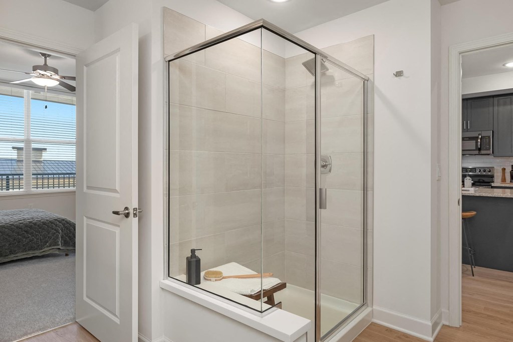 a bathroom with a shower and a door to a bedroom