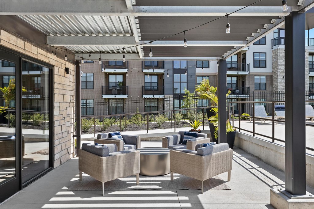 an outdoor patio with chairs and tables and a building in the background