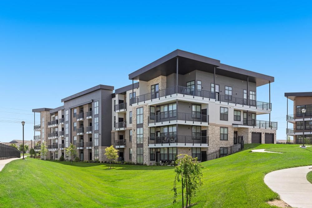 a rendering of an apartment building on a green field