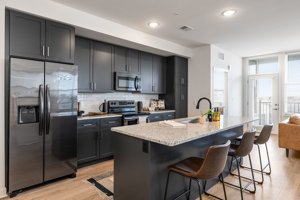 a kitchen with stainless steel appliances and a marble counter top