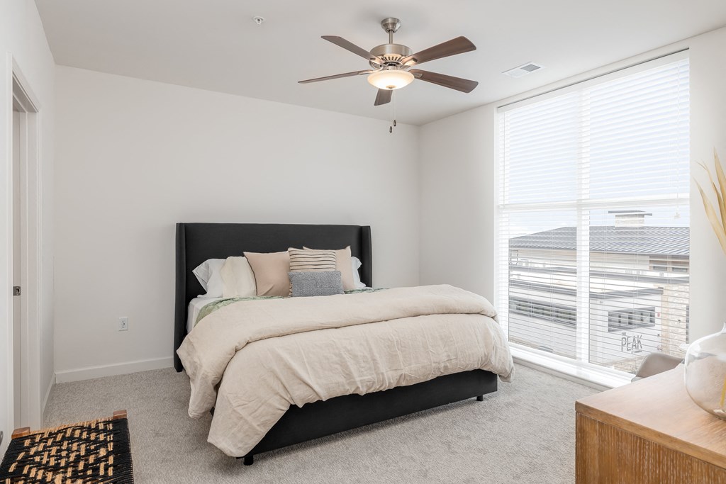 a bedroom with a bed and a ceiling fan