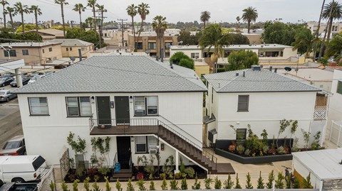 a white house with a gray roof in a neighborhood