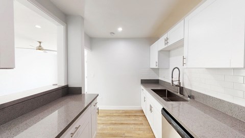 a renovated kitchen with granite counter tops and white cabinets