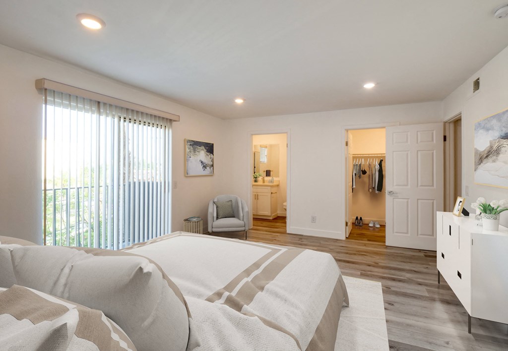 a bedroom with a large bed and a door to a bathroom