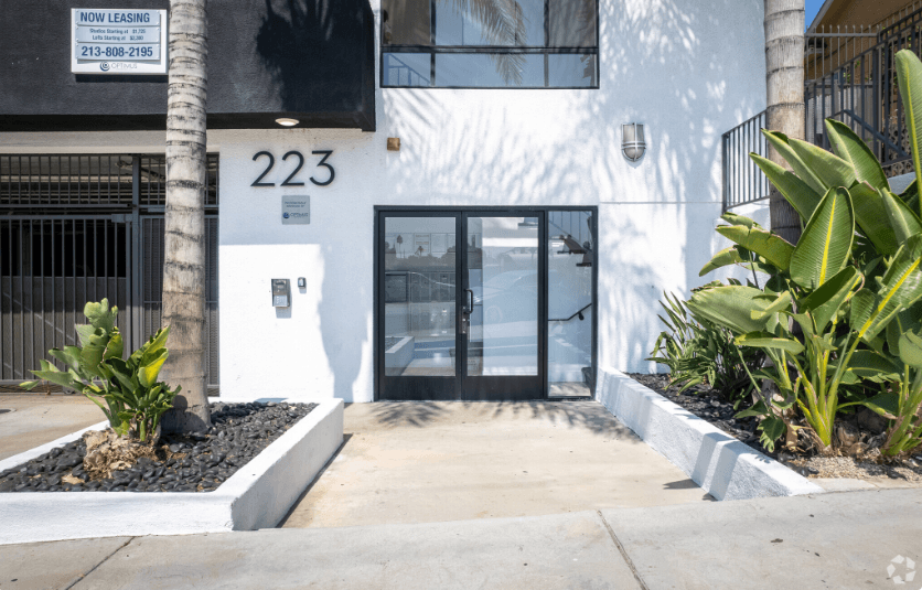 a white building with a glass door and a sidewalk