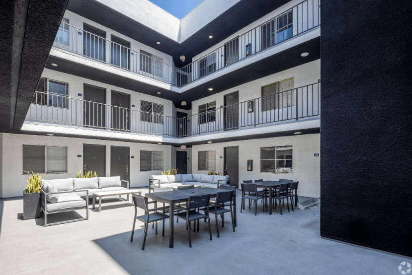 the lobby of a building with tables and chairs