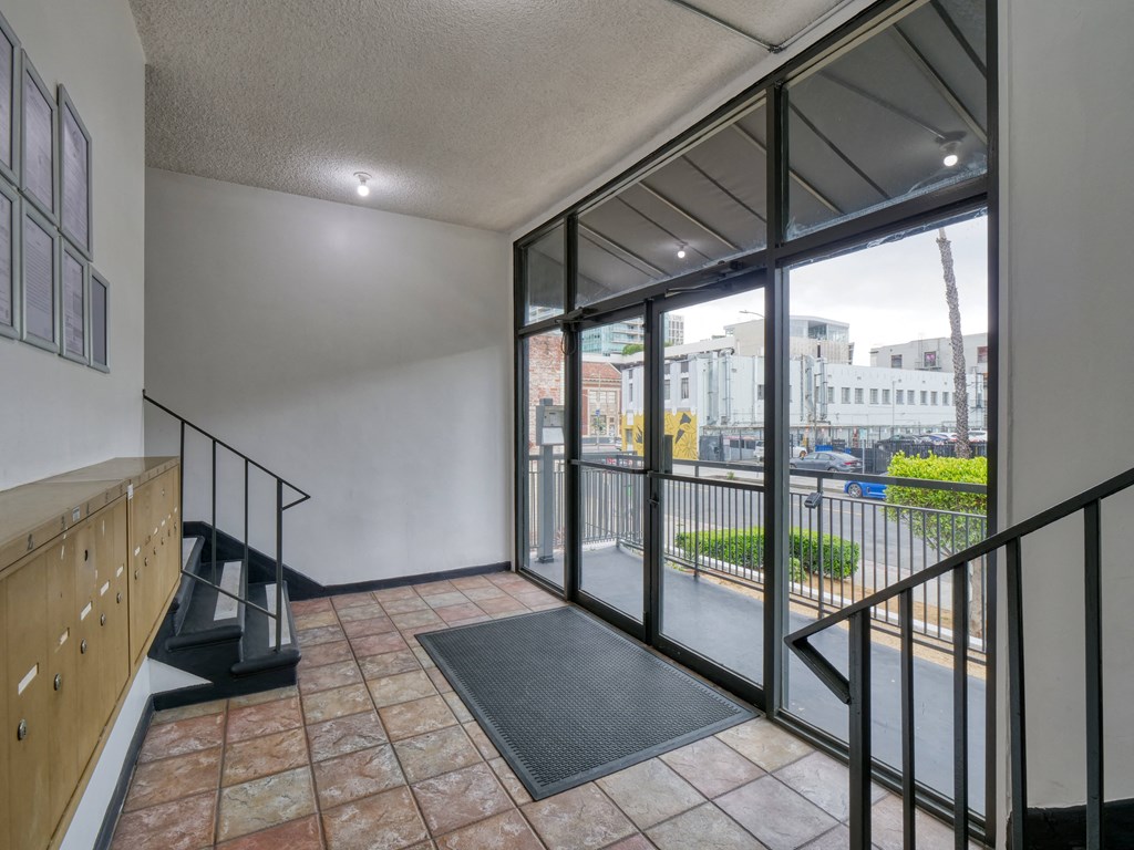 the entrance to a condo with glass doors and a balcony