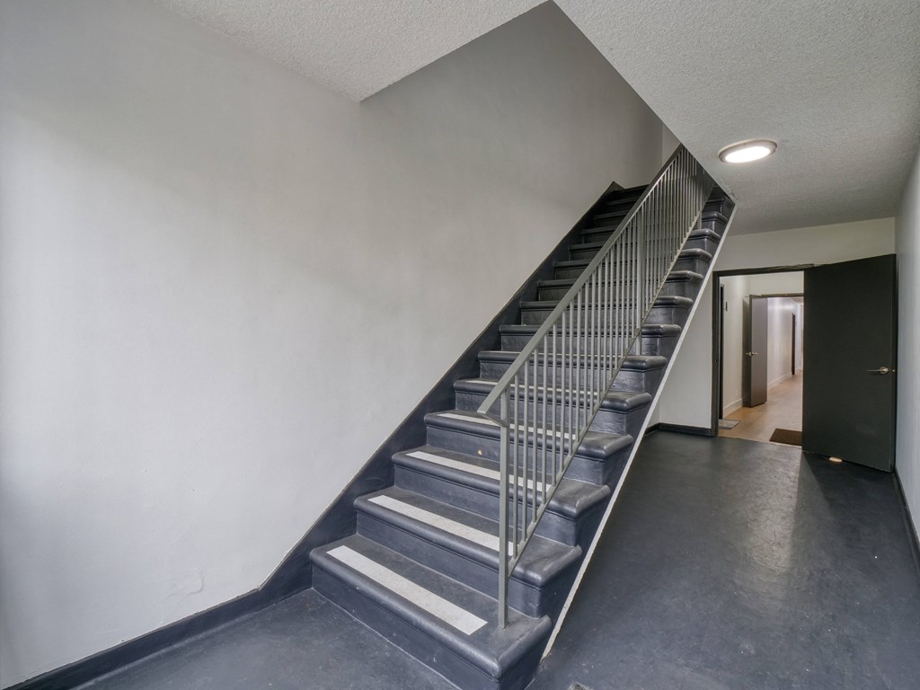 a stainless steel staircase in a building and a metal handrail