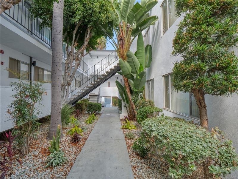 a sidewalk in front of a building with a staircase
