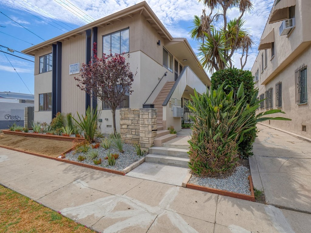 a house with stairs and a sidewalk in front of it