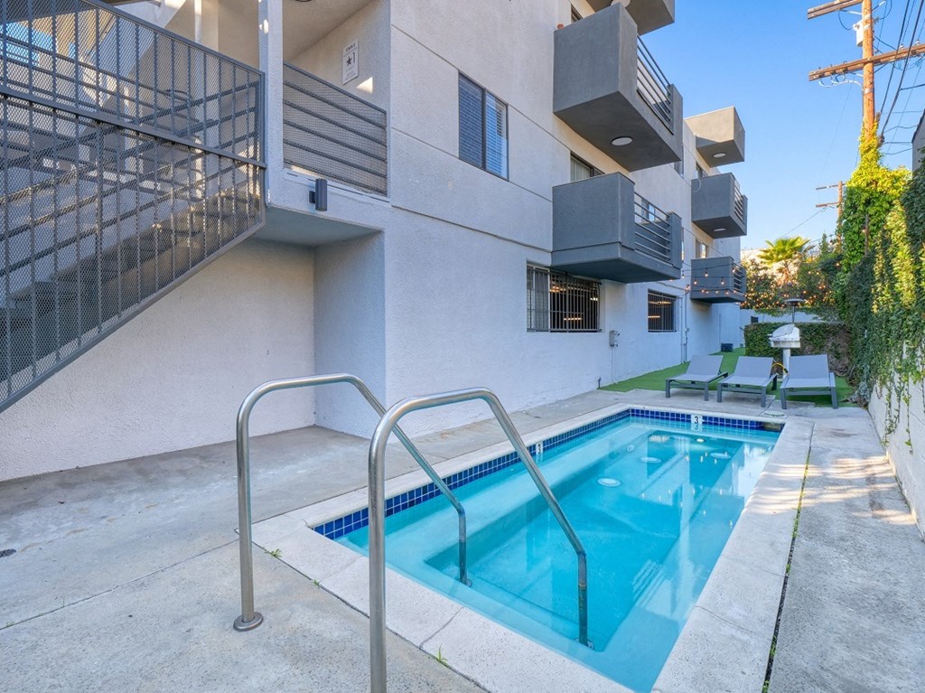 the pool is in front of a building with a swimming pool