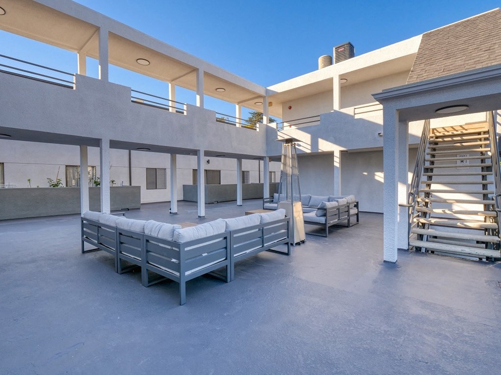 a large patio with benches and a bed in the middle of a building