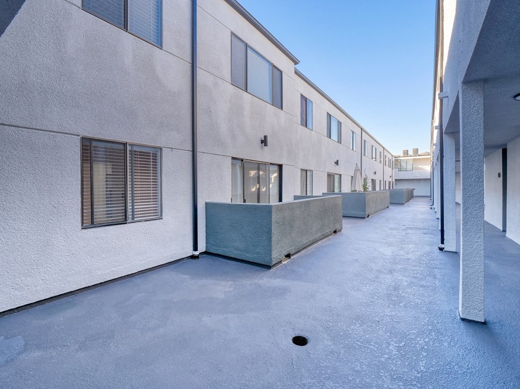 the courtyard of an apartment building with a blue sky in the background