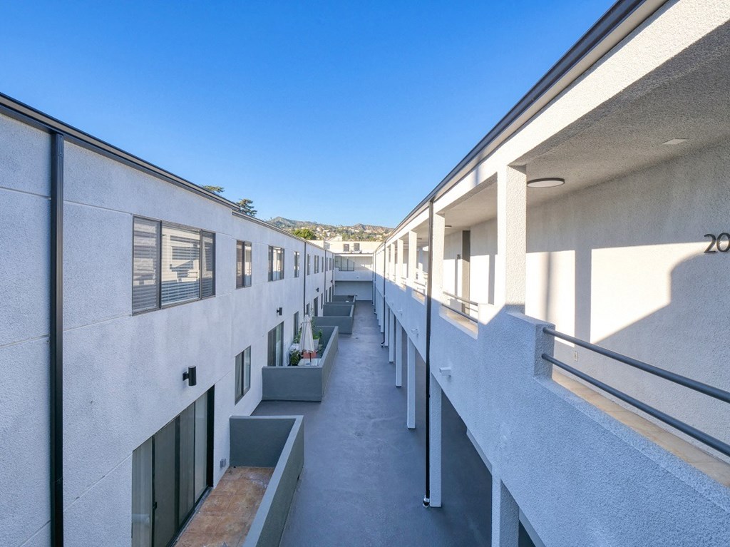 the corridor of a building with many windows and balconies