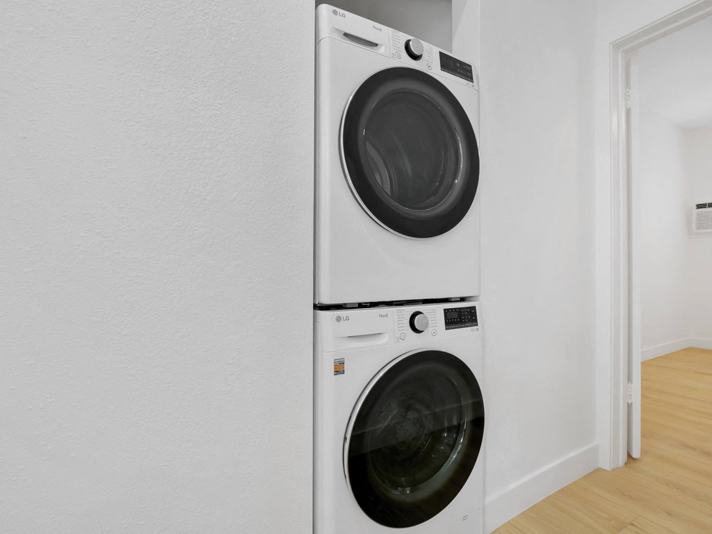 a white washer and dryer in a white laundry room