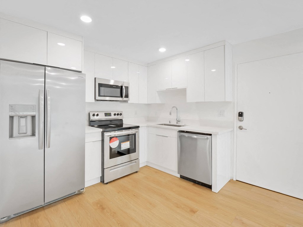 a kitchen with white cabinetry and stainless steel appliances