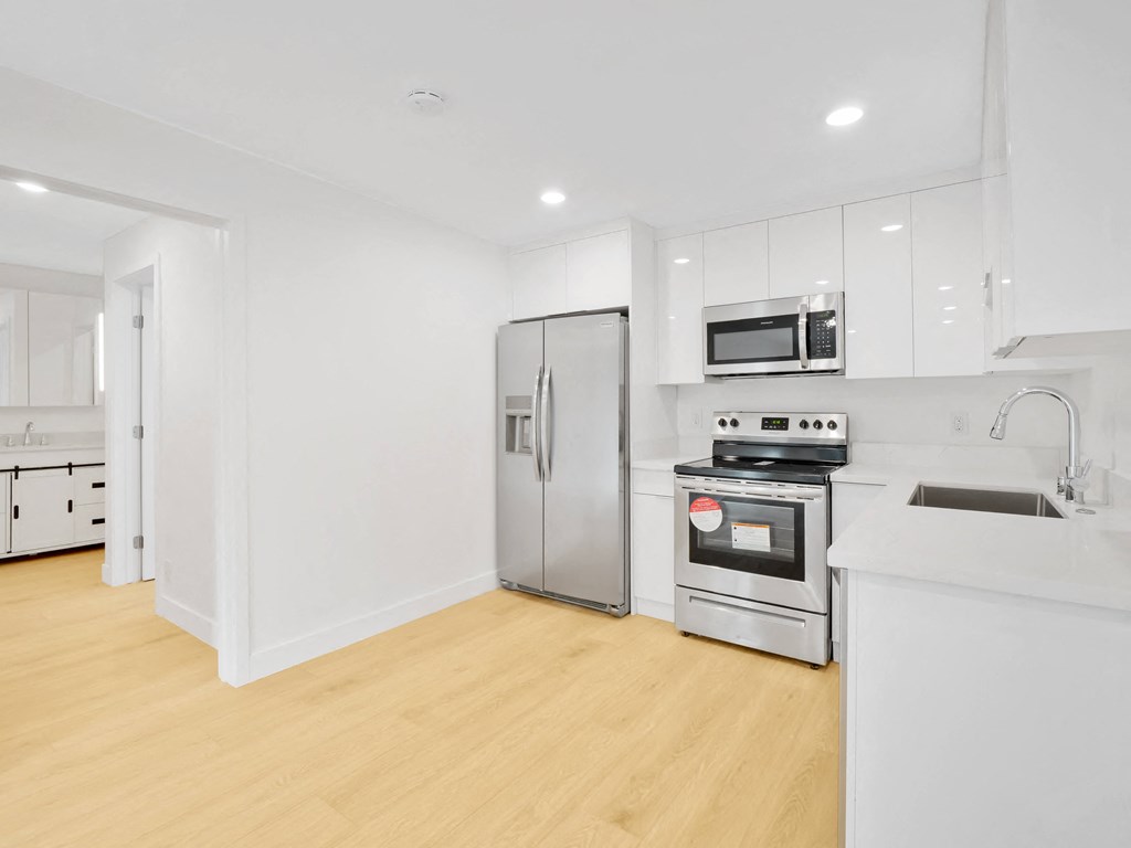 a kitchen with white cabinetry and stainless steel appliances