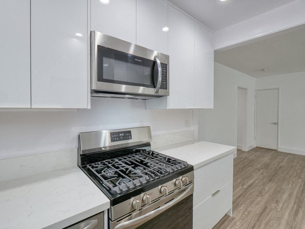 a kitchen with white cabinets and a stove and a microwave
