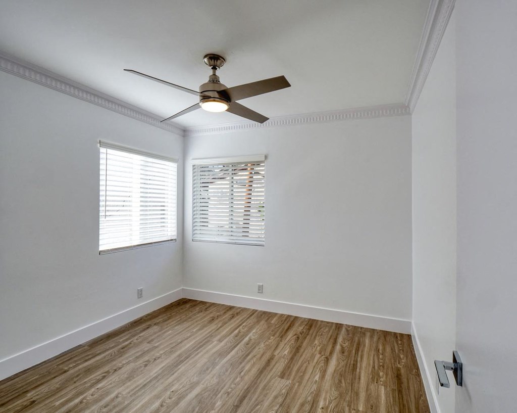 an empty room with a ceiling fan and a window